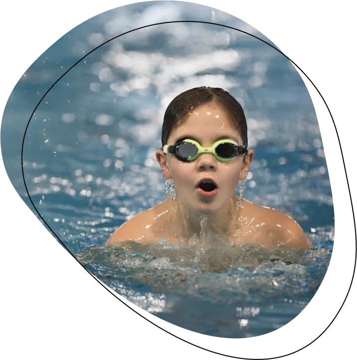 Junger Schwimmer mit Chlorbrille im Wasser